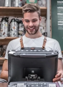 vendeur bar café devant son logiciel de caisse pour son magasin