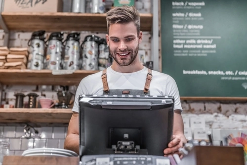 vendeur bar café devant son logiciel de caisse pour son magasin