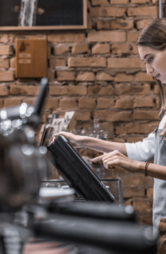 Commerçante de proximité sur sa caisse enregistreuse