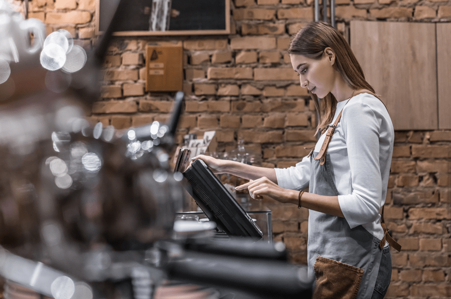 Commerçante de proximité sur sa caisse enregistreuse